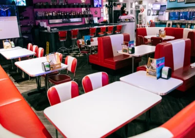 1950s diner interior with red and white booths and bar area