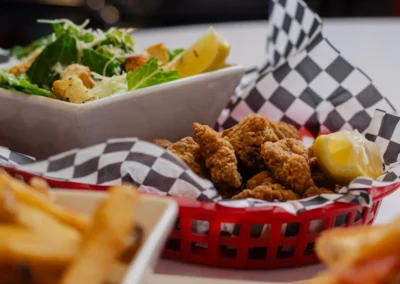 A close-up view of a red basket filled with crispy fried chicken strips